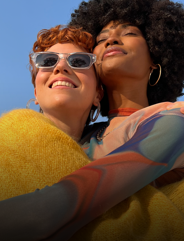 A vibrant photograph of two people embracing, demonstrating the Pro-level camera capabilities of iPhone 14.
